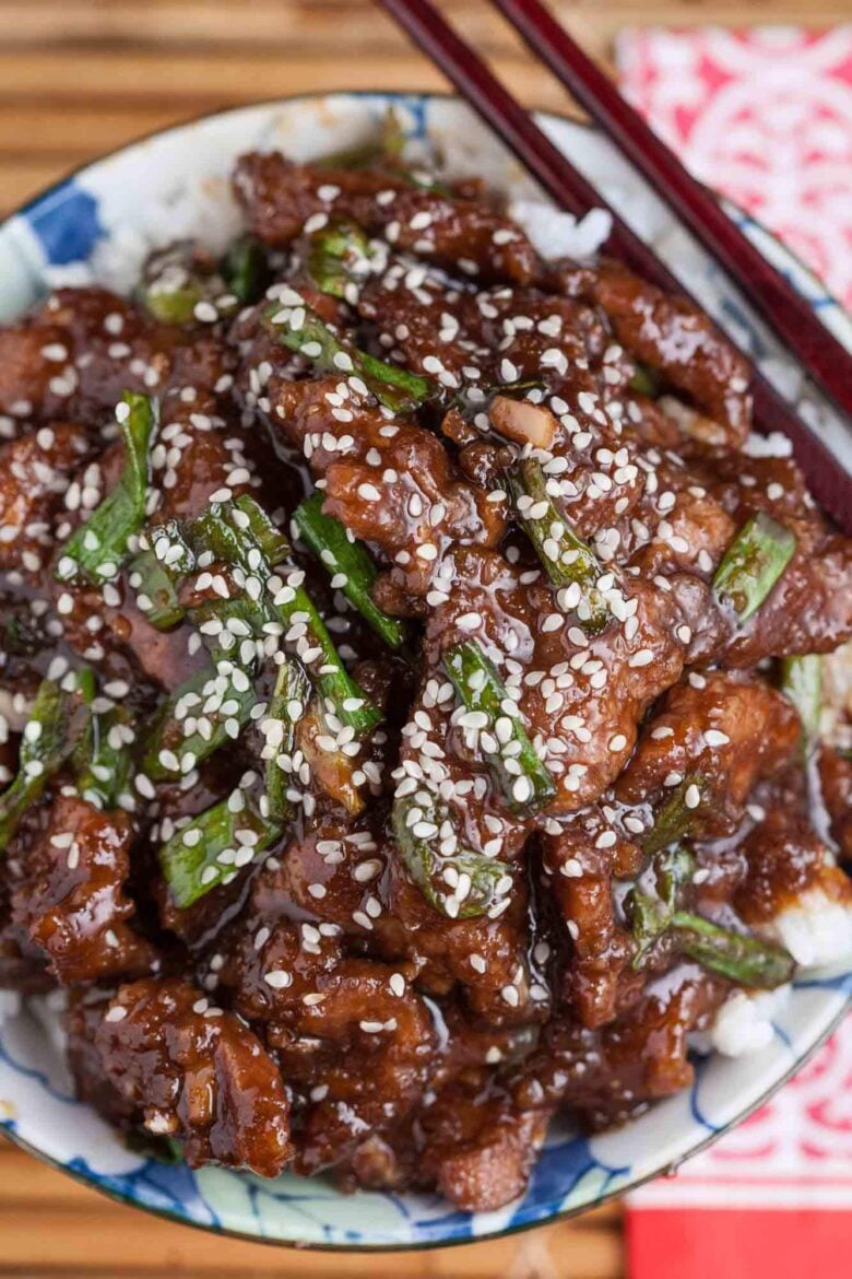 Overhead shot of a bowl with homemade Mongolian beef recipe with sesame seeds on top.