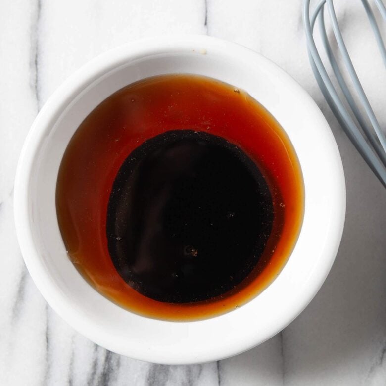 Honey and balsamic vinegar in a bowl to make drizzle for peach crostini.