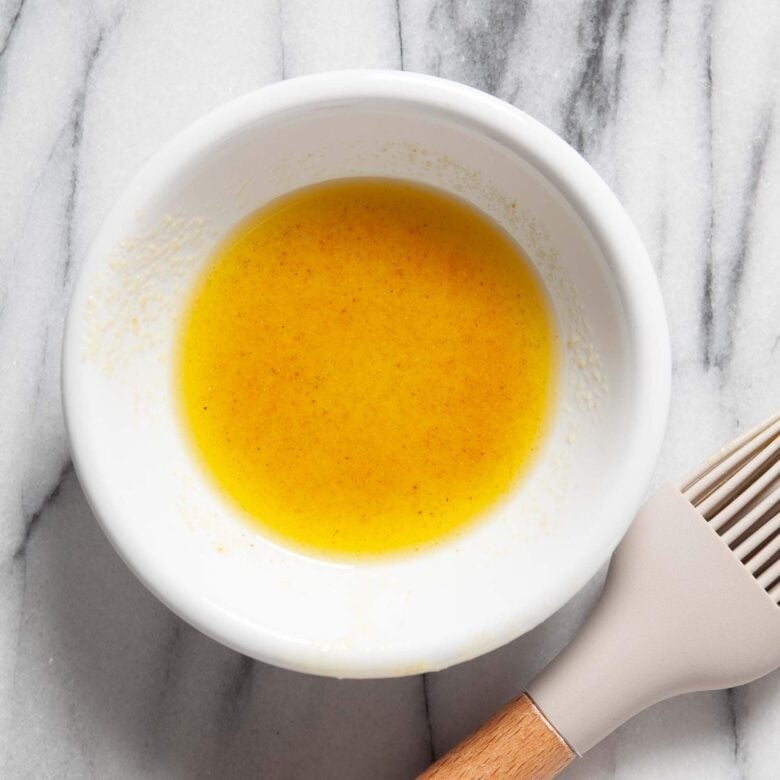 Garlic powder and oil mixed in a bowl to make peach crostini.