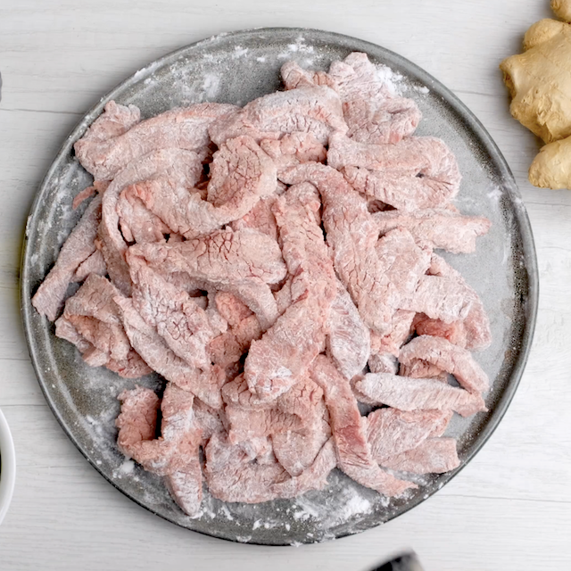 Cornstarch coated beef strips left to rest to make mongolian beef at home.