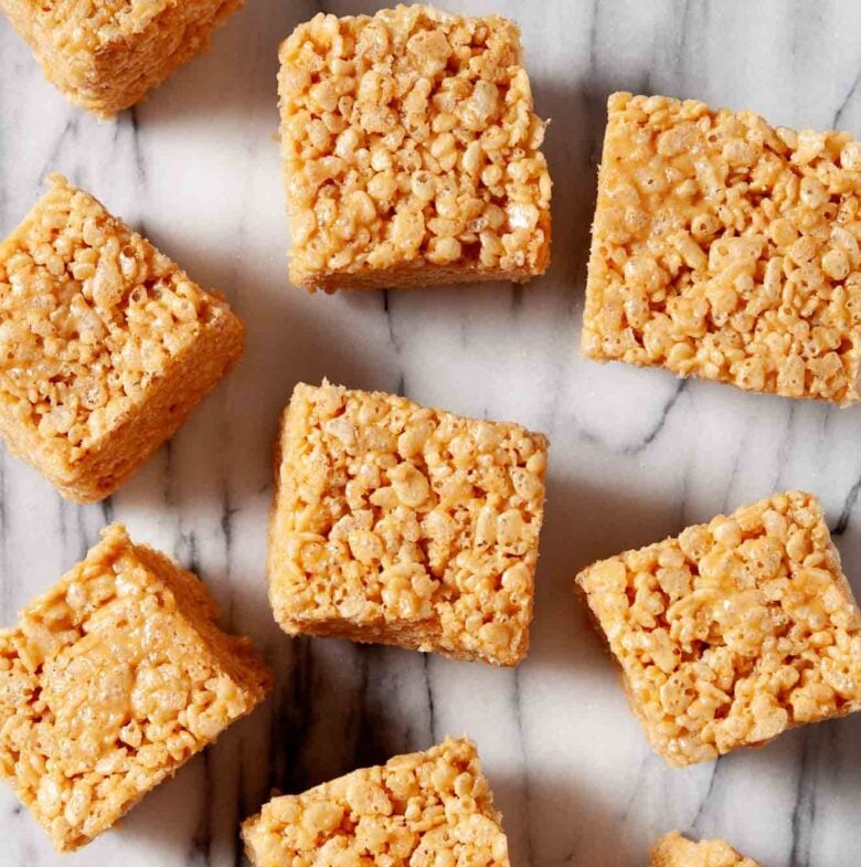 Overhead shot of homemade healthy rice krispie treat squares on a marbled surface.