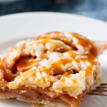 Closeup shot of a apple pie bar, drizzled with homemade salted caramel sauce.