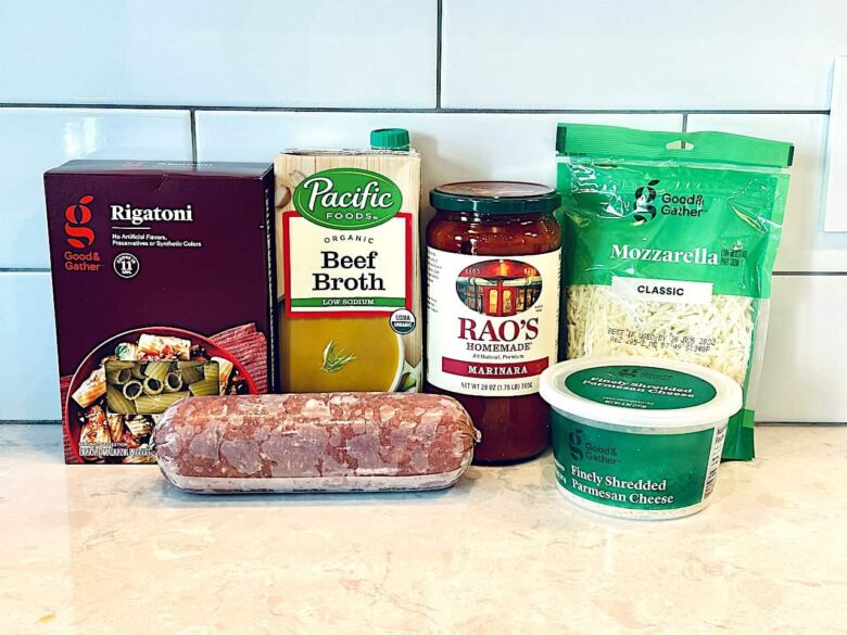 baked rigatoni ingredients with pasta, beef, broth, sauce, and cheese.