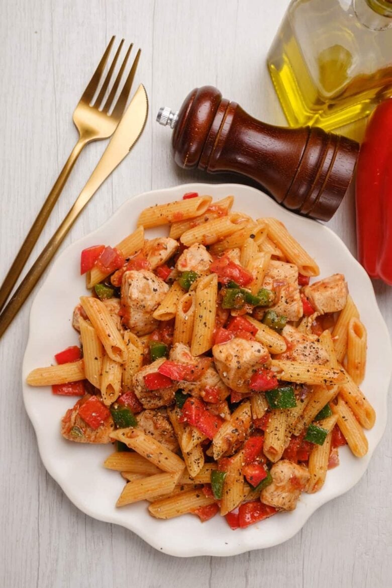 Overhead shot of a white plate with chicken fajita pasta.