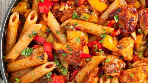 A skillet filled with Chicken Fajita Pasta all prepared as a one-pan quick meal and garnished with fresh herbs.
