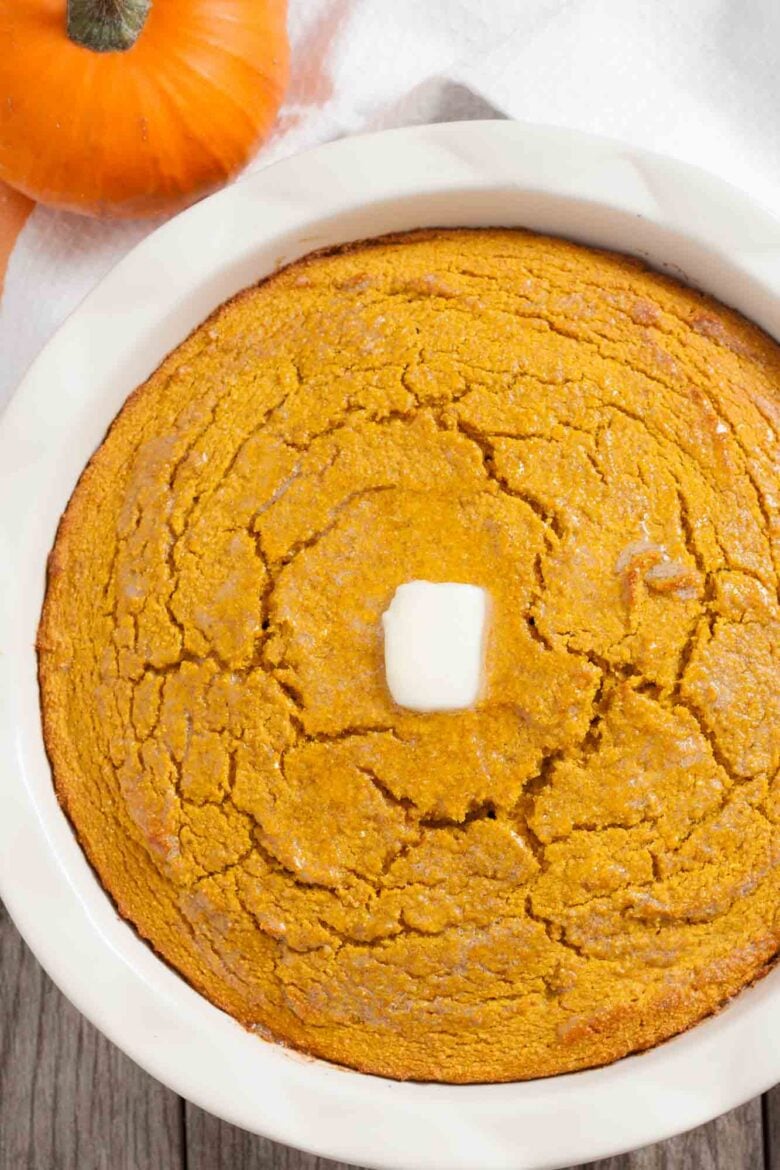 Overhead shot of a freshly baked pumpkin cornbread with butter on top.