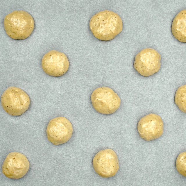 Pumpkin donut hole dough on a baking sheet.