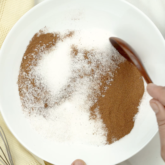 Cinnamon and sugar being mixed together in a bowl.