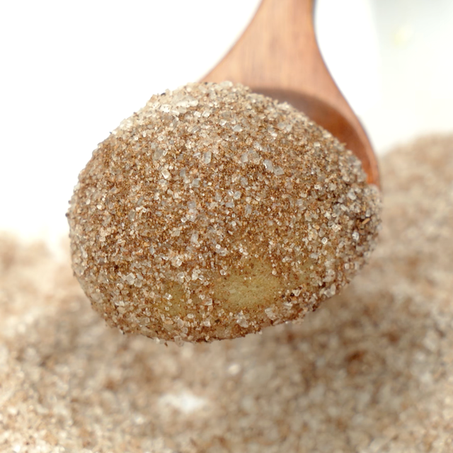 Pumpkin donut hole tossed into cinnamon sugar mixture.
