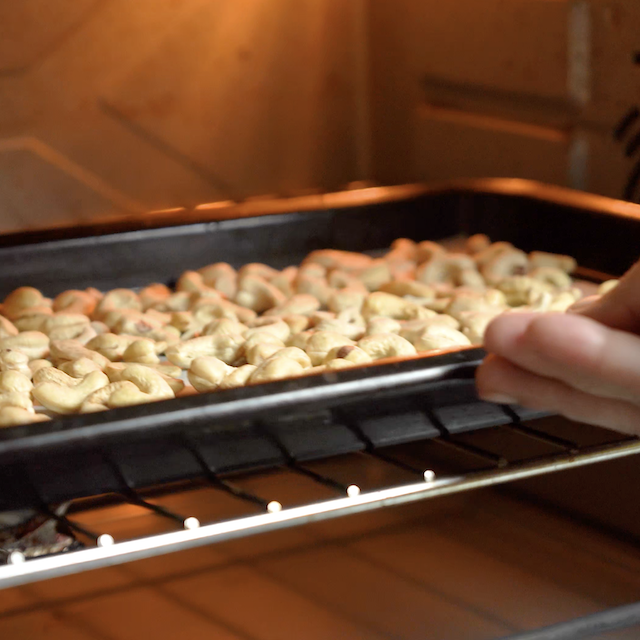 Cashews being placed in the oven to make roasted cashews.