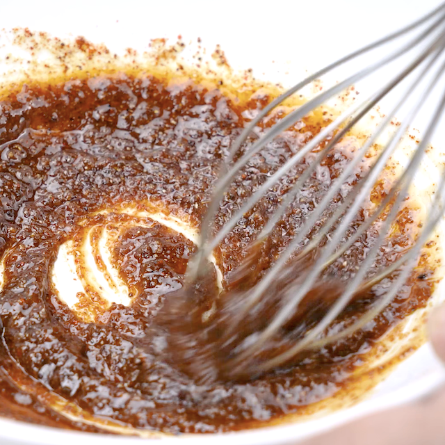 Spice and butter mixture being whisked together to make roasted cashews.