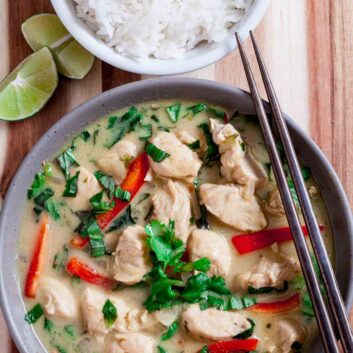 Overhead shot of a bowl with thai chicken curry, with chopsticks on the side.