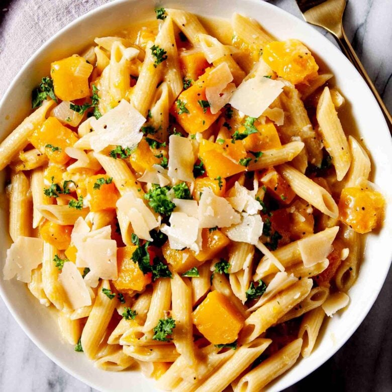 Overhead shot of a bowl with homemade butternut squash pasta with a fork on the side.