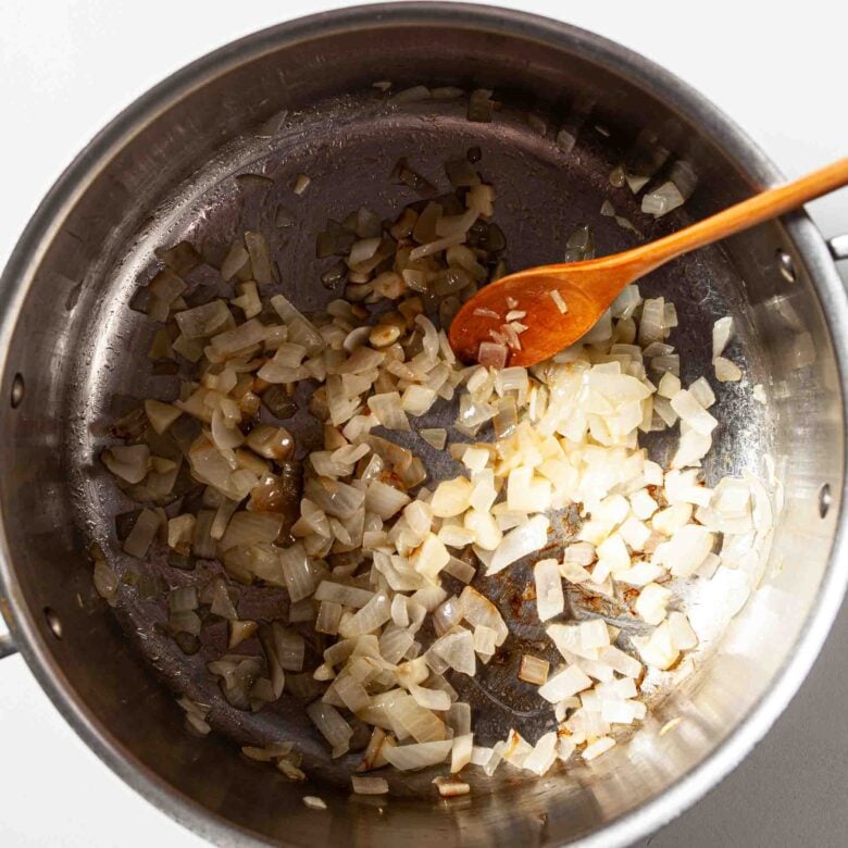 Garlic and onions being sautéed in a pot to make butternut squash pasta.