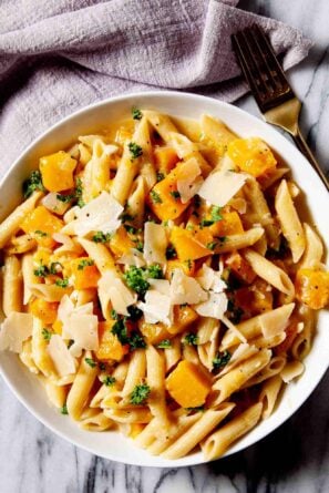 Overhead shot of a bowl with homemade butternut squash pasta with a fork on the side.