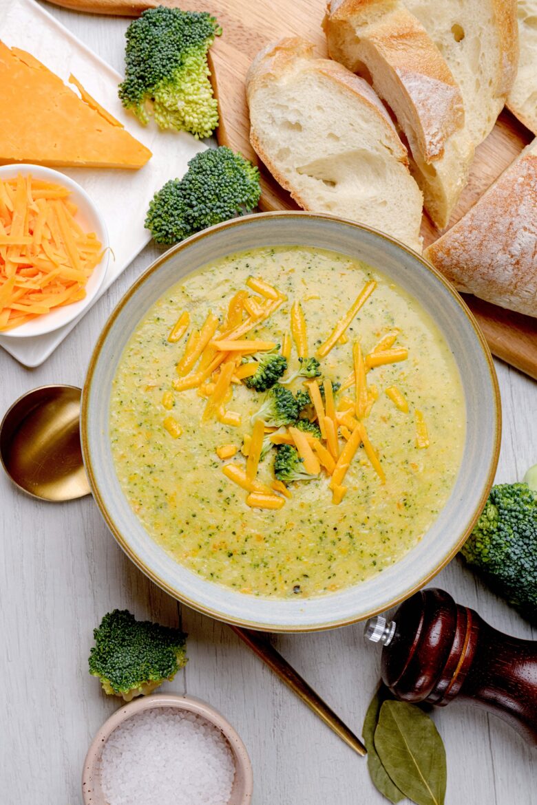 Overhead shot of broccoli cheese soup with shredded cheese and broccoli florets.