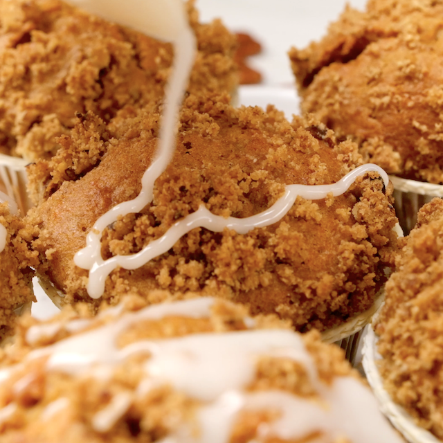 Glaze being drizzled on top of homemade sweet potato muffins.