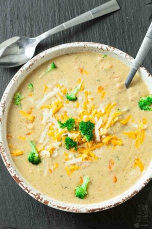 Overhead shot of a bowl of broccoli cheese soup with a spoon.