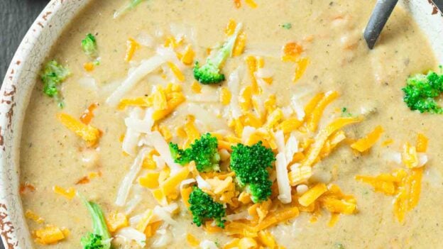 Overhead shot of a bowl of broccoli cheese soup with a spoon.
