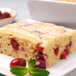 A slice of cranberry cake with simple icing on top.