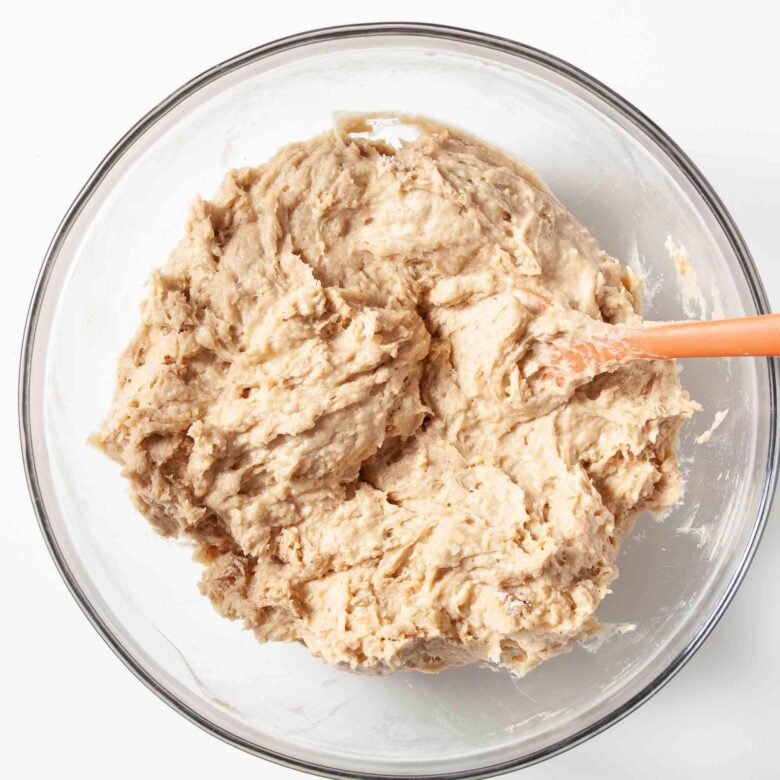 Snickerdoodle batter in a glass bowl with a spatula.