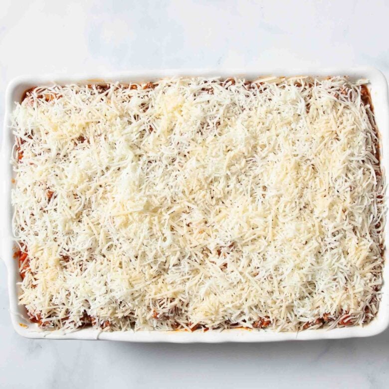 ravioli casserole with cheese on top in pan before going in oven.