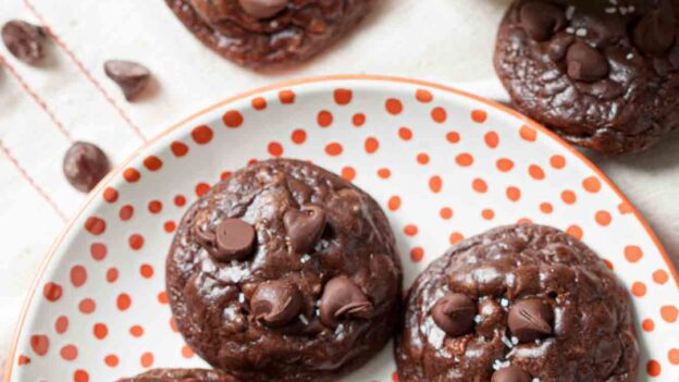 Brownie Cookies on a plate with a glass of milk on the side.