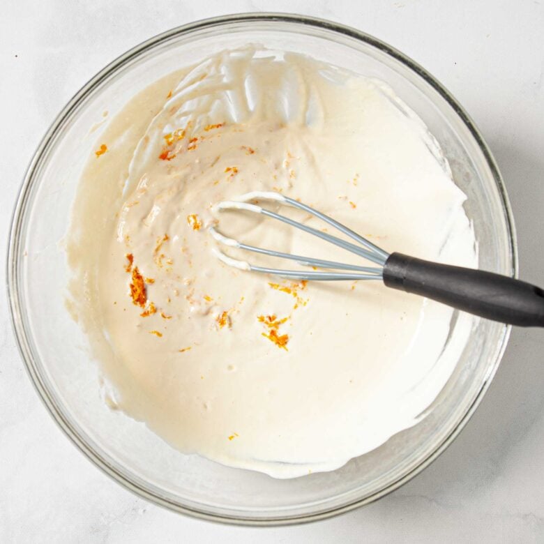 Mixed wet ingredients to make scones in a bowl with a whisk.