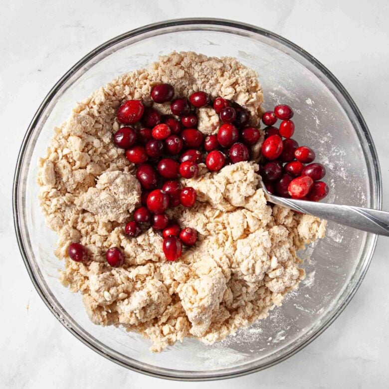 Cranberries in a bowl with scone dough.