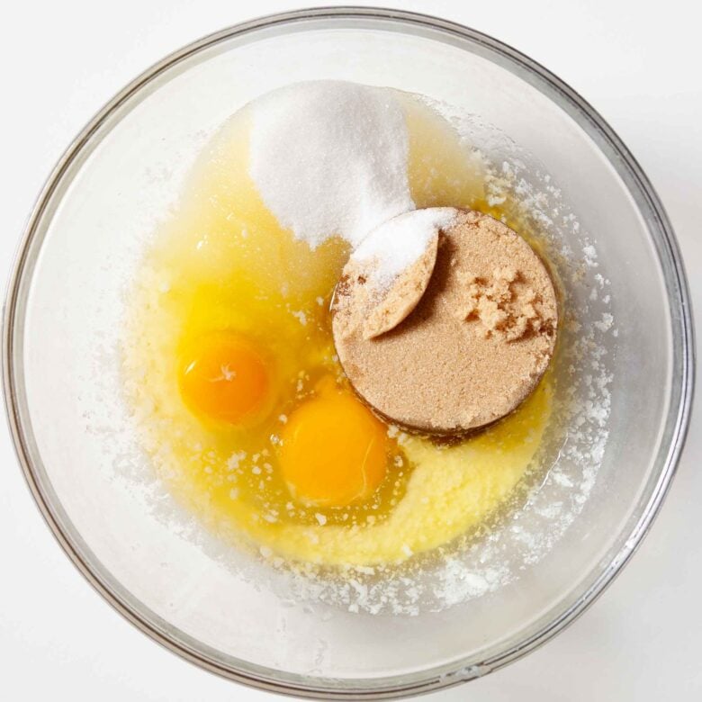 Egg, melted butter and sugars in a bowl to make m&m cookie bars.