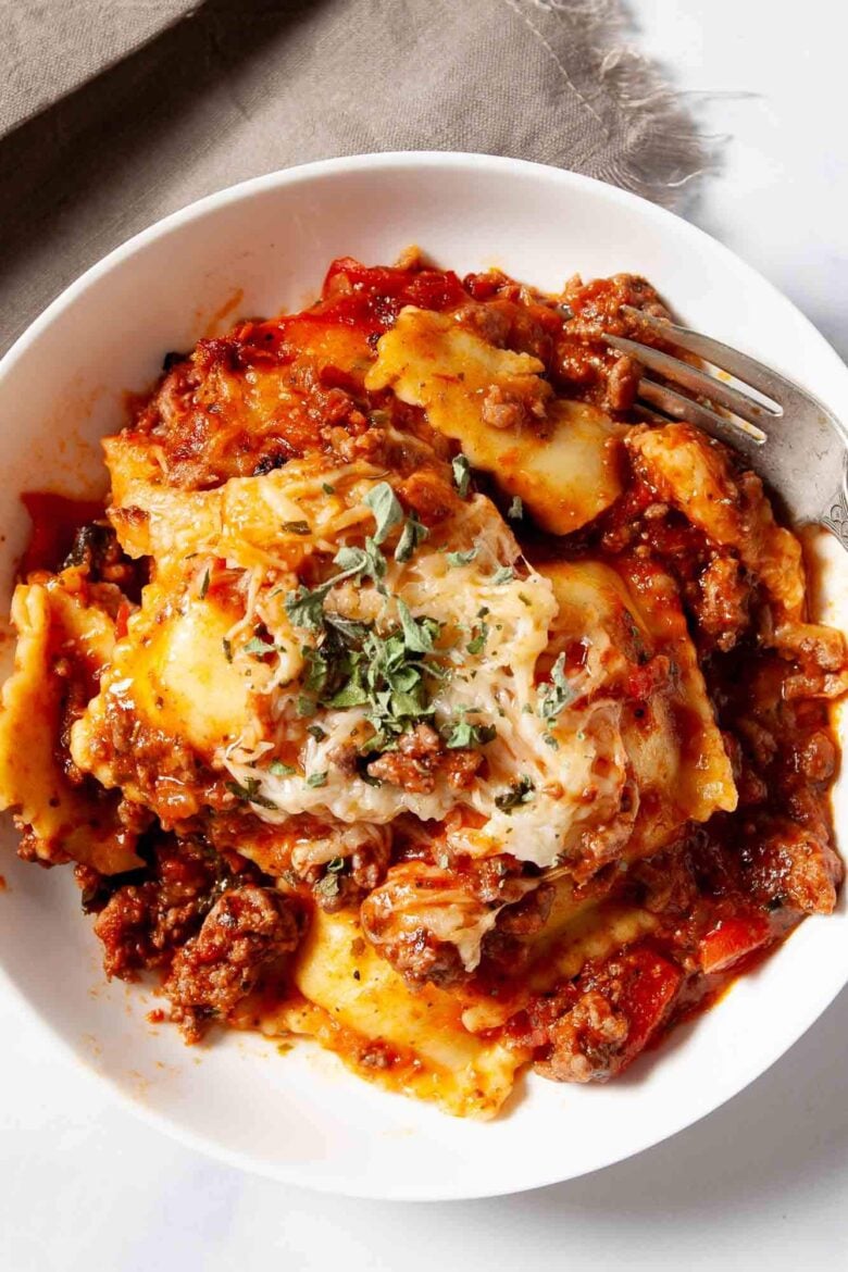 Baked ravioli casserole with cheese and meat sauce on a plate.