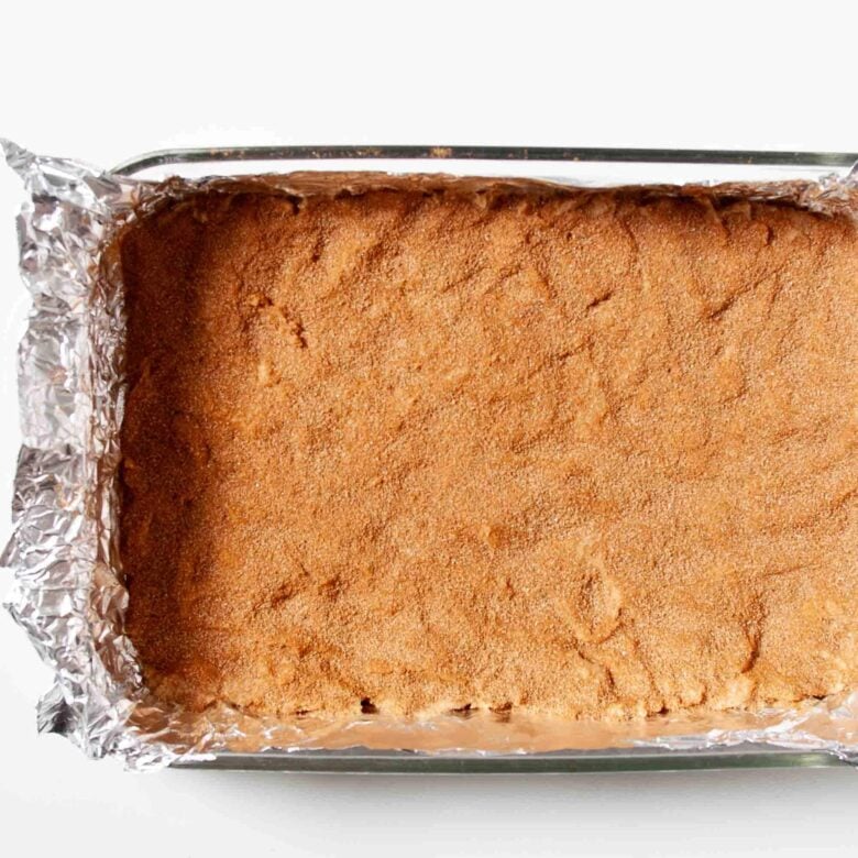 Snickerdoodle bar batter pressed evenly in prepared pan.