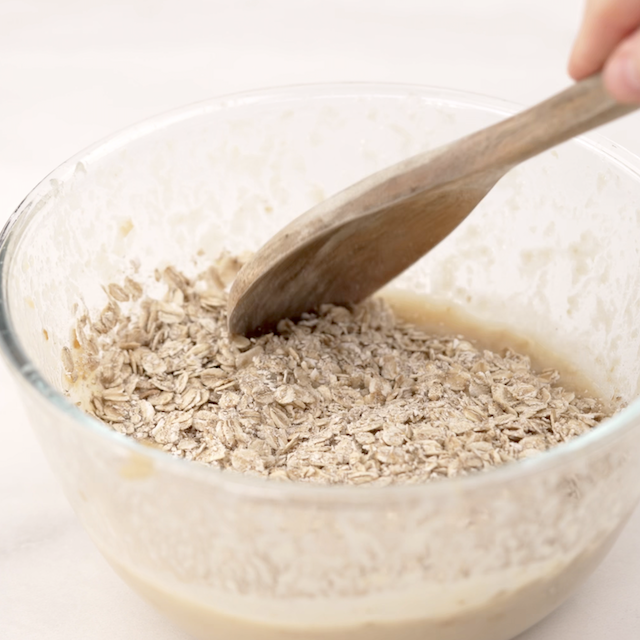 Dry ingredients being folded into wet ingredients to make apple oatmeal bars.