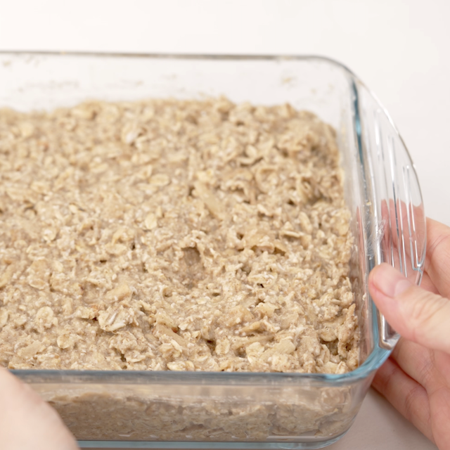 Apple oatmeal bar batter in a prepared pan, ready to bake.