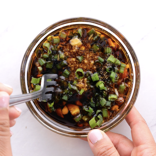 Asian baked salmon marinade ingredients being whisked in a bowl.