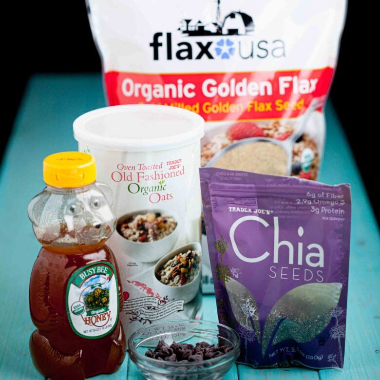 Ingredients to make peanut butter energy balls on a blue surface.