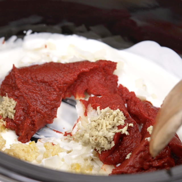 Yogurt and aromatics to make chicken tikka masala in a slow cooker.