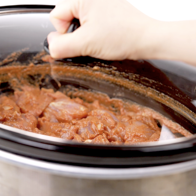 Lid being placed on slow cooker. to start cooking chicken tikka masala.
