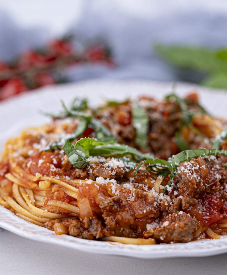 Italian sausage on a plate with fresh herbs on top.
