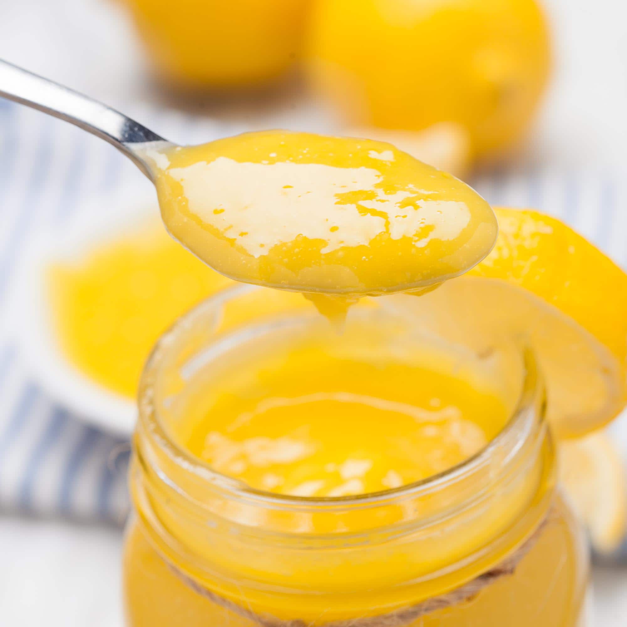 lemon curd homemade in a jar and spoonful.