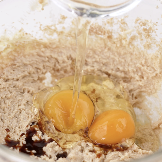 Vanilla and eggs in a bowl of creamed butter and sugar.