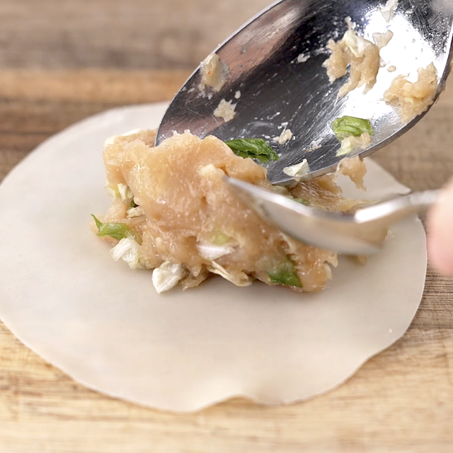 Filling being added to potstickers wrapper.