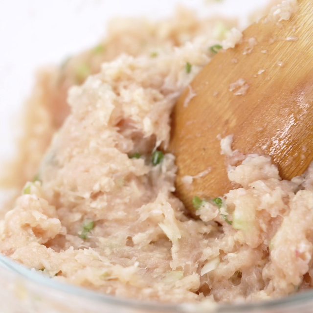 Buffalo chicken meatballs mixture being mixed in a glass bowl.