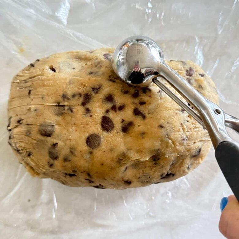 Dough balls being scooped with a cookie scoop.