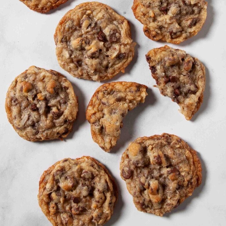 Overhead shot of coconut chocolate chip cookies on a marbled surface.
