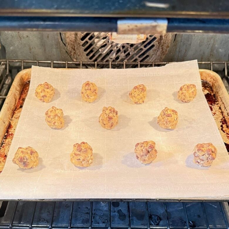 Coconut chocolate chip cookie balls being baked in the oven.