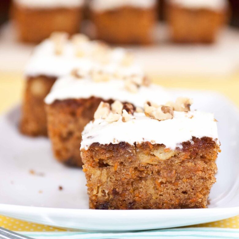 Easy carrot cake sliced into 3 squares and plated on a serving dish.