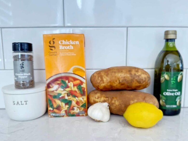 Ingredients to make greek lemon potatoes on a white kitchen counter.