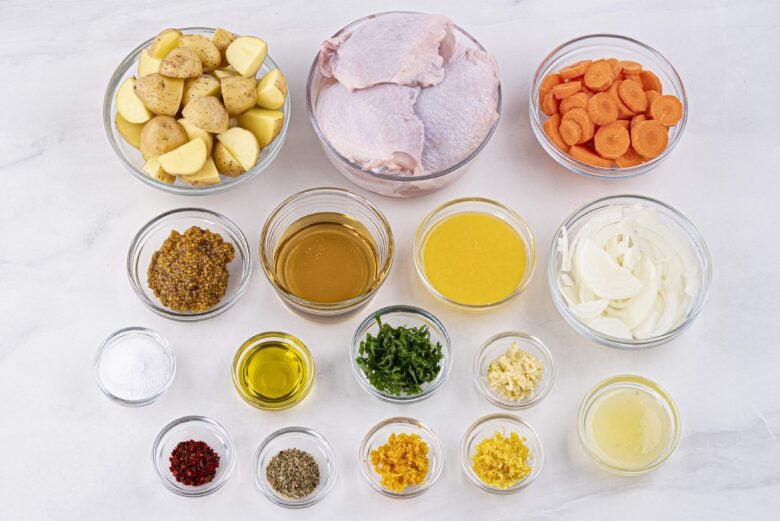 Ingredients to make sheet pan chicken and potatoes on a light surface.