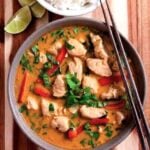 Thai Chicken Coconut Curry in a bowl with chopsticks, rice, and lime slices.